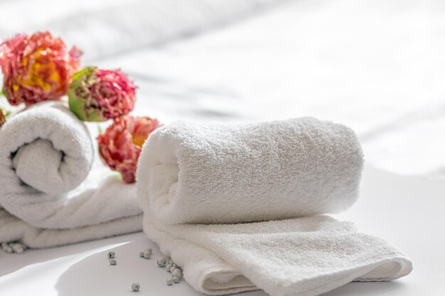 Zbliżenie białe ręczniki kąpielowe frotte i kwiaty