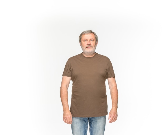 Zbliżenie ciała starszego mężczyzny w pusty brązowy t-shirt na białym tle. Odzież, makiety do rezygnacji z koncepcji z miejsca na kopię. Przedni widok