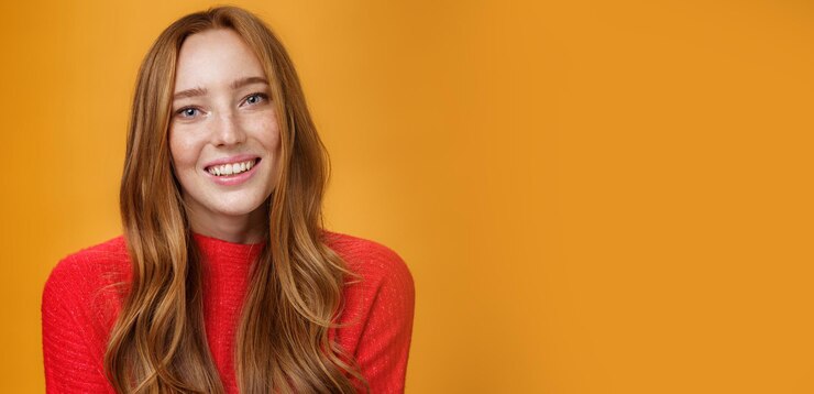 Bezpłatny plik Zdjęcie zbliżenie delikatny delikatny i uroczy rudzielec cutie z długą naturalną fryzurą uśmiechający się radośnie wi