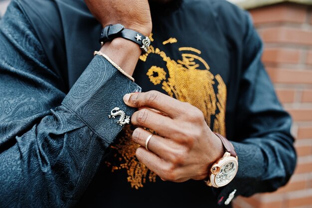 Zbliżenie dłoni bogatego afrykańskiego mężczyzny z zegarkiem i spinkami do mankietów