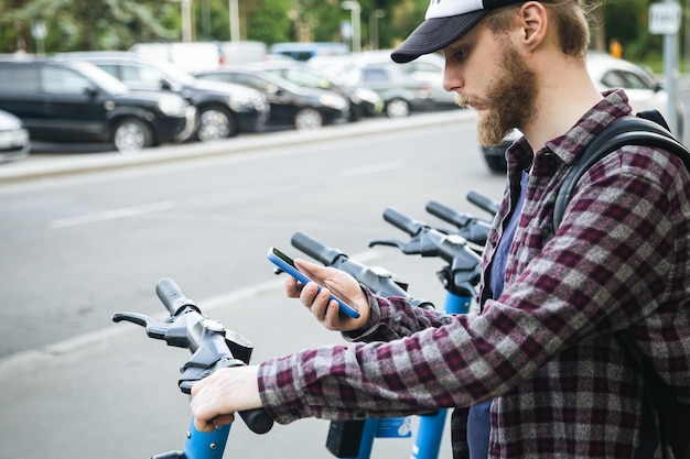 Bezpłatne zdjęcie zbliżenie dłoni człowieka za pomocą aplikacji mobilnej do wypożyczenia skutera elektrycznego