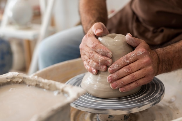 Zbliżenie dłoni robiących ceramikę w pomieszczeniu