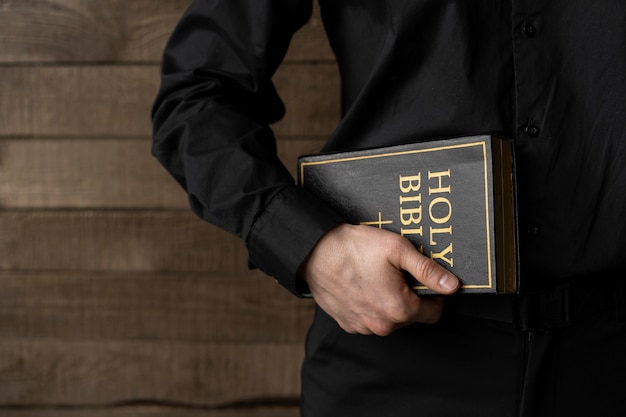 Zbliżenie dłoni trzymającej Biblię