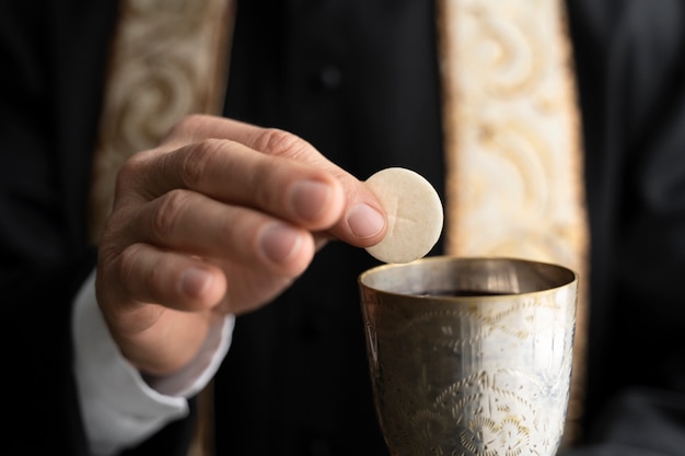 Zbliżenie dłoni trzymającej Eucharystię