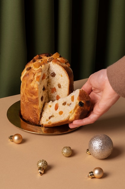 Zbliżenie dłoni trzymającej plasterek panettone