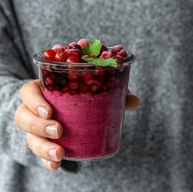 Bezpłatne zdjęcie zbliżenie dłoni trzymającej szkło owocowe smoothie