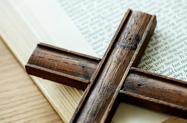 Zbliżenie drewniany krzyż na biblii książki