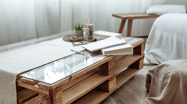Zbliżenie: drewniany stół z książkami w pokoju w stylu skandynawskim.