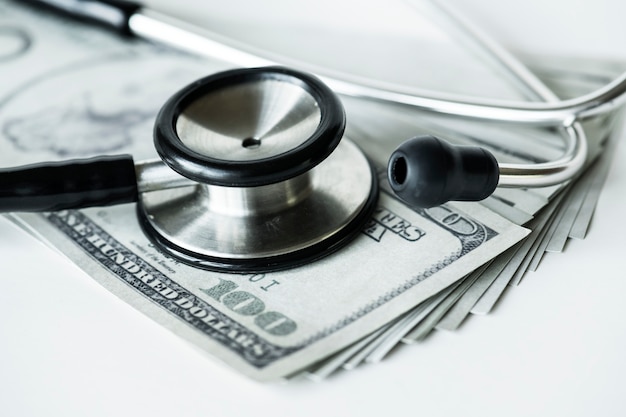 Zbliżenie gotówka i stetoskopu opieka zdrowotna i koszty pojęcie