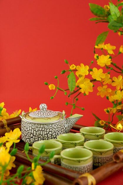 Zbliżenie herbata set słuzyć przeciw czerwonemu tłu i kwiatom