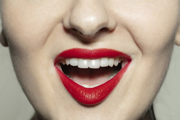 Zbliżenie kobiece usta z jaskrawoczerwonymi ustami połysk