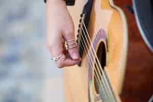 Bezpłatne zdjęcie zbliżenie kobieta bawić się gitarę akustyczną