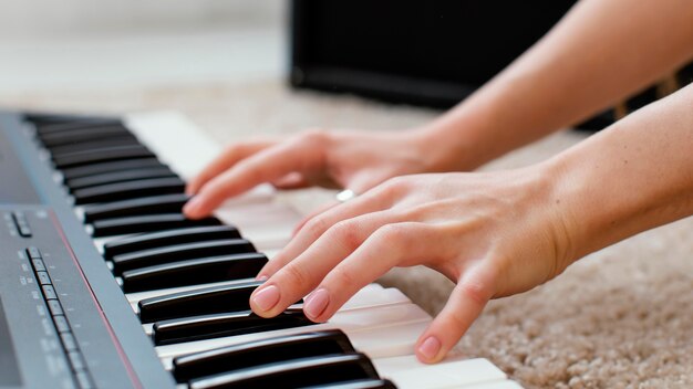 Zbliżenie: kobieta muzyk grający na klawiaturze fortepianu