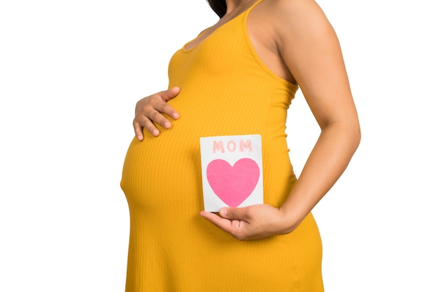 Zbliżenie: kobieta w ciąży, trzymając kartkę z życzeniami