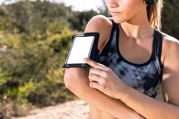 Zbliżenie kobieta z telefonu armband makietą