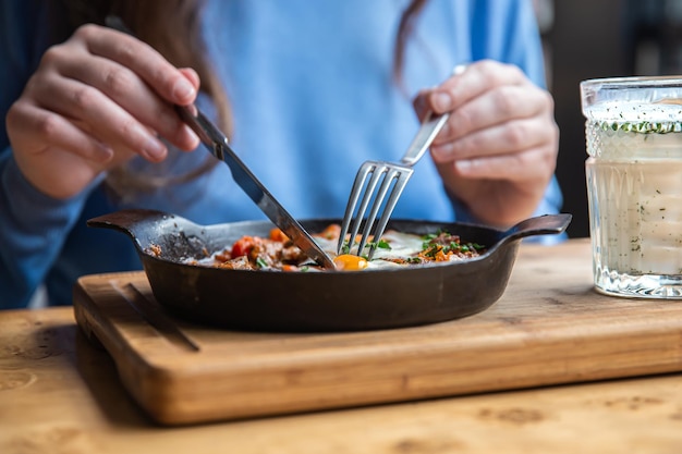 Zbliżenie kobiety w kawiarni jedzącej tradycyjne shakshuka