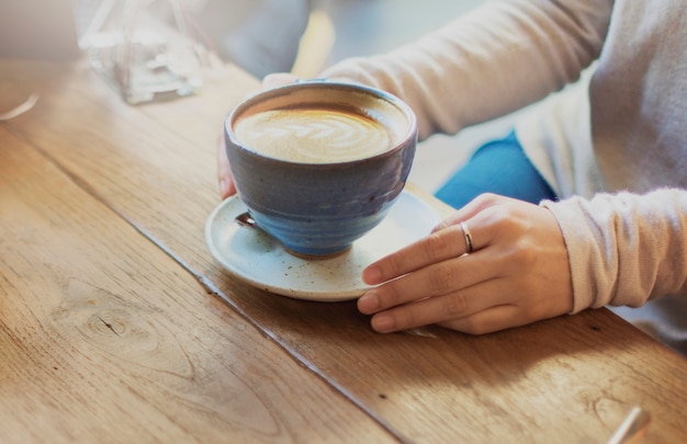Zbliżenie latte sztuki filiżanka na drewnianym stole