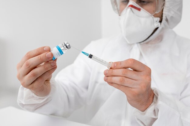 Zbliżenie lekarza posiadającego szczepionkę COVID