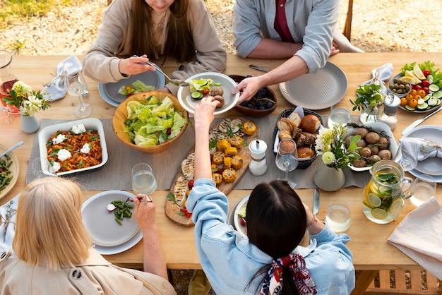 Bezpłatne zdjęcie zbliżenie ludzi przy stole z pysznym jedzeniem