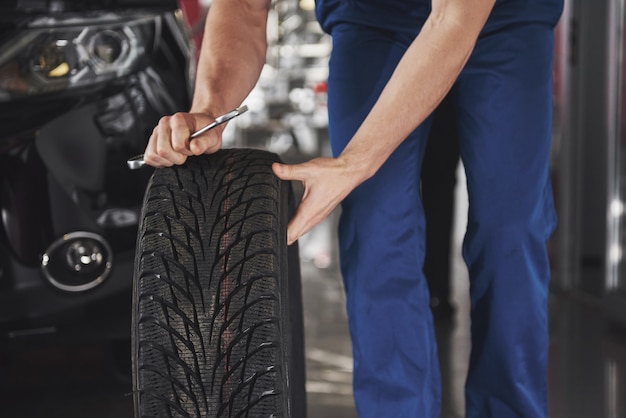 Bezpłatne zdjęcie zbliżenie mechanika pokazano ok gest kciukiem, trzymając klucz.