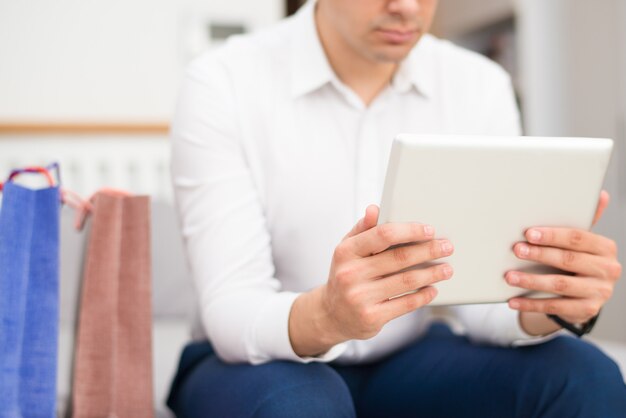 Zbliżenie mężczyzna zakupy i wyszukiwać na komputerze typu tablet