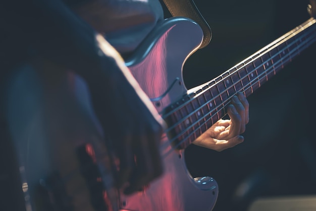Zbliżenie mężczyzny grającego na gitarze basowej