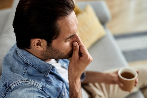 Zbliżenie mężczyzny z wirusem grypy pijącym herbatę w domu