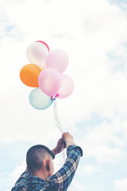 Zbliżenie młodego człowieka z balonami w rękach