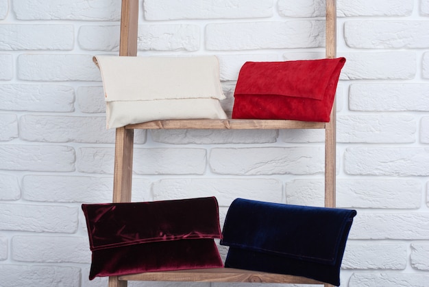 Bezpłatne zdjęcie zbliżenie: modne czerwone, białe, niebieskie i bordowe torebki damskie, leżące na białej ścianie.