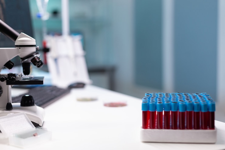 Bezpłatny plik Zdjęcie zbliżenie na biurko laboratoryjne z profesjonalnym sprzętem badawczym. taca próżniowa z krwią do badania mikroskopowego, mikropipety i mikroskopu. narzędzia do rozwoju nauki