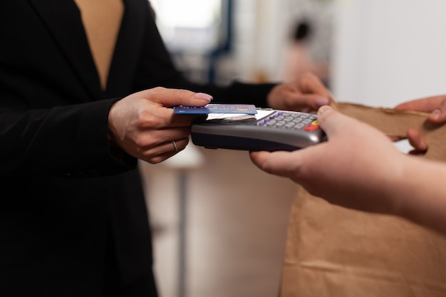 Zbliżenie na biznes kobieta trzyma kartę kredytową z pos
