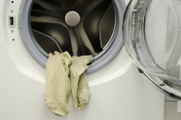 Zbliżenie na brudne pranie zwisające z pralki