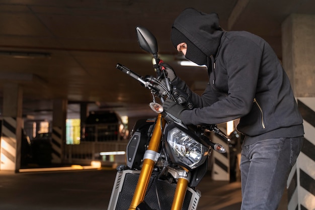 Zbliżenie na człowieka przygotowującego się do kradzieży motocykla