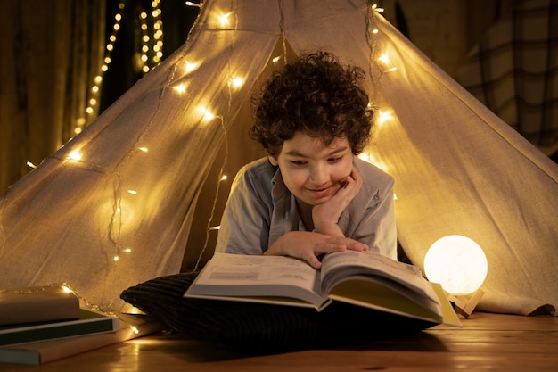 Zbliżenie Na Czytanie Dziecka W Jego Domowym Namiocie Premium Zdjęcia