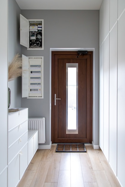 Zbliżenie na drewniane drzwi w przedpokoju w stylu minimalizmu.
