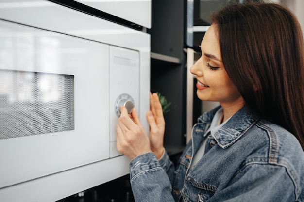 Zbliżenie na kobietę sprawdzającą nową kuchenkę mikrofalową w hipermarkecie