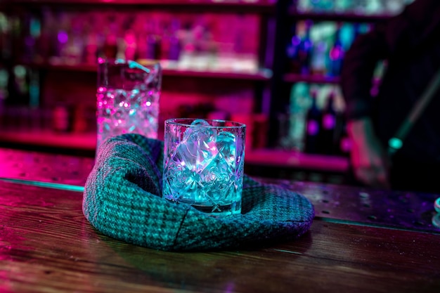 Zbliżenie na koktajl alkoholowy, napój, napój, szklankę pełną lodu w wielobarwnym neonowym świetle