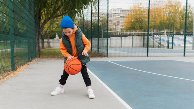 Bezpłatne zdjęcie zbliżenie na małego chłopca grającego w koszykówkę