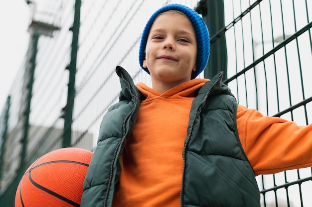 Bezpłatne zdjęcie zbliżenie na małego chłopca grającego w koszykówkę