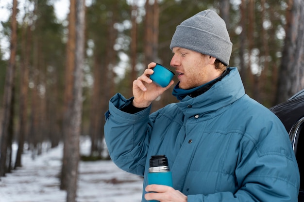 Zbliżenie na mężczyznę cieszącego się gorącym napojem podczas zimowej wycieczki