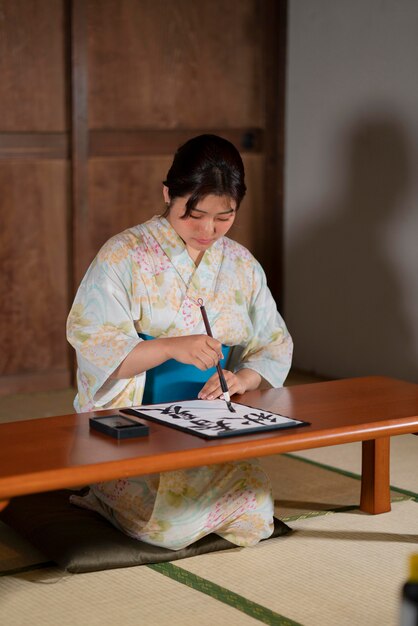 Zbliżenie na nauczyciela wykonującego japońską kaligrafię, zwaną shodo