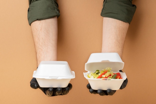 Bezpłatne zdjęcie zbliżenie na ręce trzymające pojemniki na żywność