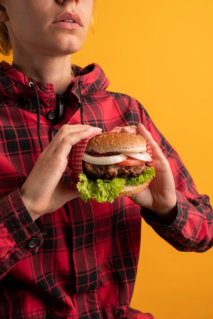 Zbliżenie na ręce trzymające pysznego burgera