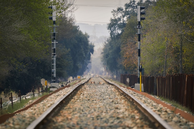 Bezpłatne zdjęcie zbliżenie na tory kolejowe i drewniany płot po prawej stronie