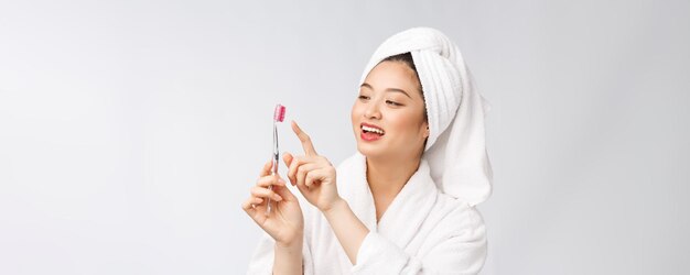 Zbliżenie na uśmiech kobieta szczotkuje zęby idealne dla koncepcji opieki stomatologicznej na białym tle na białym tle asian
