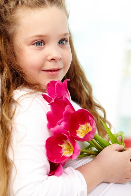 Zbliżenie niewinnej dziewczynki z kwiatami