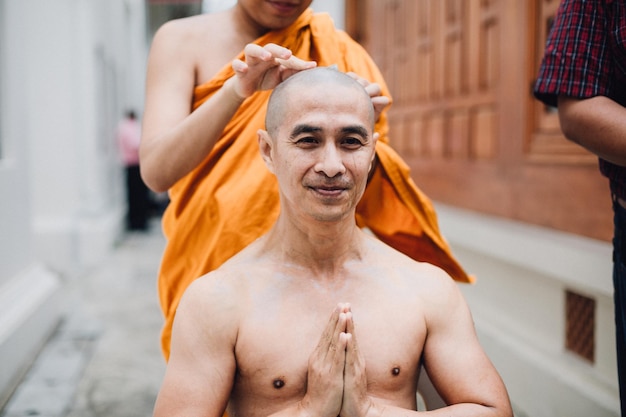 Bezpłatne zdjęcie zbliżenie obrazu przystojnego azjatyckiego mężczyzny goli włosy przez głowę mężczyzny, który jest wyświęcony w buddyzmie