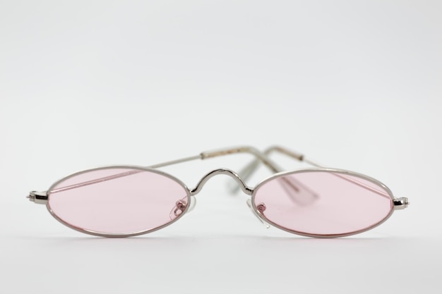 Zbliżenie okularów z różowymi soczewkami na białym tle