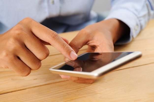 Zbliżenie osoba używa smartphone przy stołem