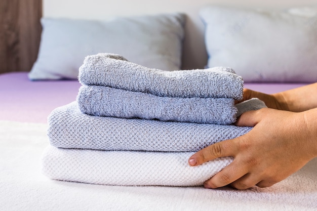 Zbliżenie osoby stawianie ręczników na łóżku